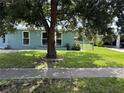 A cozy one-story home with well-kept lawn, shadowed by a mature tree at 2513 Ambrose Ln, Port Charlotte, FL 33952