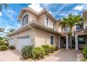 Charming townhouse exterior with lush landscaping, a two-car garage, and a welcoming front entrance at 2630 Tarpon Cove Dr # 211, Punta Gorda, FL 33950