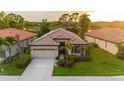 Inviting single story home boasting a tile roof, attached two car garage, and mature landscaping at 2712 Arugula Dr, North Port, FL 34289