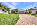 Charming home with brick driveway, attached garage, and well-maintained front lawn at 27896 Arrowhead Cir, Punta Gorda, FL 33982