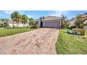 Landscaped yard, long brick driveway and an attached garage on a beautiful property at 27896 Arrowhead Cir, Punta Gorda, FL 33982