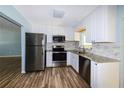 Modern kitchen featuring stainless steel appliances, granite countertops, white cabinetry, and stylish backsplash at 3085 Arrowhead Rd, Venice, FL 34293