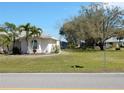 This beautifully landscaped yard features mature trees, a well-maintained lawn, and attractive shrubbery at 388 Orlando Blvd, Port Charlotte, FL 33954