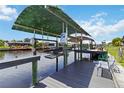 Private boat dock and lift on the canal with a gray wood deck and a green sunshade at 4123 Rock Creek Dr, Port Charlotte, FL 33948
