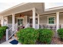 Charming front porch with seating, lovely landscaping, and decorative details, offering a welcoming entrance at 437 South Dr, Punta Gorda, FL 33950