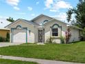 Single-story home featuring stucco siding, blue trim, and a well-maintained front lawn at 464 Rose Apple Cir, Port Charlotte, FL 33954