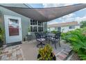 Enjoy outdoor dining on the brick patio with a shade sail, perfect for relaxing or entertaining at 477 Ricold Ter, Port Charlotte, FL 33954