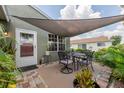 Enjoy outdoor dining on the brick patio with a shade sail, perfect for relaxing or entertaining at 477 Ricold Ter, Port Charlotte, FL 33954