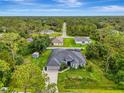 Expansive aerial view of a home nestled among trees with a long driveway and well-maintained yard at 6444 Alhambra Ave, North Port, FL 34291