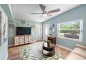 Living room featuring a TV, cabinet, ceiling fan, front door, and a leaf-patterned rug at 1027 Coral Ridge Dr, Punta Gorda, FL 33950