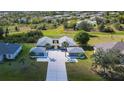 Aerial view showcasing the home's unique layout with a central courtyard, expansive driveway, and lush landscaping at 1115 San Cristobal Ave, Punta Gorda, FL 33983