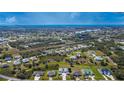 Scenic aerial view of a residential area with well-maintained homes, interspersed with green spaces, and a nearby lake at 1115 San Cristobal Ave, Punta Gorda, FL 33983