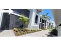 Condominium exterior with a screened in patio with plants and tropical landscaping at 12390 Wellen Golf St # 202, Venice, FL 34293