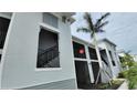 View of the condominium exterior featuring private screened in patios and tropical landscaping at 12390 Wellen Golf St # 202, Venice, FL 34293