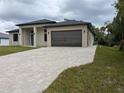 Contemporary exterior with a paved driveway leading to an attached two-car garage at 136 Sequoyah Dr, Port Charlotte, FL 33954
