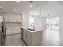 Bright, modern kitchen with white cabinets, stainless steel appliances, and a large island overlooking the living area at 14141 Heritage Landing Blvd # 921, Punta Gorda, FL 33955