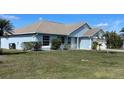 Inviting single-story home featuring a well-manicured lawn and neutral-toned roof with light-blue siding at 1708 Blue Lake Cir, Punta Gorda, FL 33983