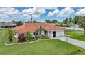 Charming home featuring lush landscaping, a vibrant tile roof, and a well-manicured lawn at 23141 Corvin Ave, Port Charlotte, FL 33954