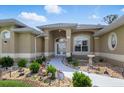 Charming single-story home featuring a landscaped walkway, arched entry, and manicured front yard at 2329 Como St, Port Charlotte, FL 33948