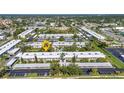 An aerial view of the complex showing multiple buildings, lush landscaping, and nearby parking areas at 2437 Harbor Blvd # 114, Port Charlotte, FL 33952