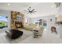 Bright living room with stone fireplace, high ceilings, and sliding glass doors to the pool at 2814 La Mancha Ct, Punta Gorda, FL 33950