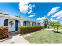 Inviting home exterior with a floral wreath and vibrant flower hedge enhances curb appeal at 330 Weber Ter, Port Charlotte, FL 33952