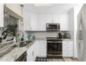 Well-lit kitchen features stainless steel appliances, granite countertops, and ample cabinet space at 330 Weber Ter, Port Charlotte, FL 33952