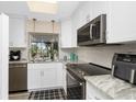 Bright kitchen features granite countertops, stainless steel appliances, and white cabinetry at 330 Weber Ter, Port Charlotte, FL 33952