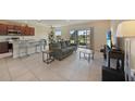 Open-concept living room with kitchen bar, tile flooring, and sliding glass doors to the lanai at 3631 Pebble Ter, Punta Gorda, FL 33980