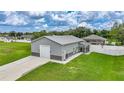 Exterior angle of a gray house with a garage, screened porch, white fence and trimmed green grass at 369 Hyacinth St, Port Charlotte, FL 33954