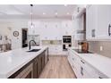 Modern kitchen with white cabinets, stainless steel appliances, and an island with countertop seating at 3800 Carupano Ct, Punta Gorda, FL 33950