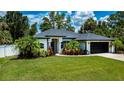 Well-maintained home with manicured lawn, beautiful plants, and a two-car garage at 3824 Dominic St, North Port, FL 34288