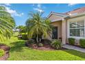 Charming front yard featuring a lush lawn and neatly trimmed landscaping and plants near the front door at 4567 Whispering Oaks Dr, North Port, FL 34287