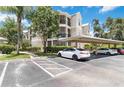 Beige condo complex featuring assigned parking, private screened lanais, and mature landscaping at 5146 Northridge Rd # 305, Sarasota, FL 34238