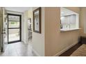 Bright entryway features tile flooring, a decorative mirror, and a pass-through to the kitchen at 5230 Lake Arrowhead Trl # 29, Sarasota, FL 34231