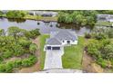 Aerial view of a white house that features a paver driveway, two car garage, and water access at 576 Mcdill Dr, Port Charlotte, FL 33953