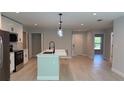 Bright, open-concept kitchen featuring a center island, stainless appliances, and sleek white cabinetry at 7052 Legion St, Port Charlotte, FL 33981
