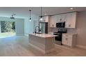 Modern kitchen featuring stainless steel appliances, white cabinets, and a central island with a sink at 7052 Legion St, Port Charlotte, FL 33981