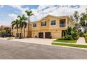Townhome exterior showcasing multi-car garages, second-floor balconies, lush tropical landscaping and well-maintained grounds at 8098 Moonstone Dr # 17-203, Sarasota, FL 34233