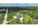 Aerial view of the home surrounded by lush greenery and trees with a pond located on the property at 8312 Acorn Blvd, Punta Gorda, FL 33982