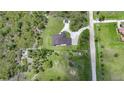 Expansive property featuring a home with a brown roof, surrounded by lush greenery and a winding driveway at 8312 Acorn Blvd, Punta Gorda, FL 33982