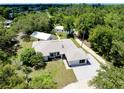 Aerial view showcases the property's lush landscaping and surrounding wooded area at 875 Bayshore Dr, Englewood, FL 34223