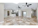 Spacious open-concept layout with tile flooring, kitchen access, and neutral tones throughout at 875 Bayshore Dr, Englewood, FL 34223