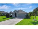Well-maintained single-story home featuring lush lawn, mature landscaping, and a two-car garage at 96 Mocha Ct, Punta Gorda, FL 33983