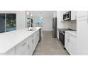 Modern kitchen with white cabinets, stainless steel appliances, and a spacious island with a lake view at 10055 Franklin Dr, Englewood, FL 34224