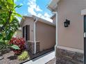 Close-up view of exterior with stone accents, lush landscaping, and manicured walkway at 10131 Winding River Rd, Punta Gorda, FL 33950