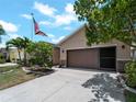 Home with two-car garage, well-kept lawn, stone accents, and beautiful landscaping on a sunny day at 10131 Winding River Rd, Punta Gorda, FL 33950