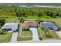 Aerial view showcases home's location near lake and surrounded by lush greenery and neighboring properties at 123 Annapolis Ln, Rotonda West, FL 33947