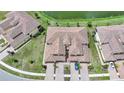 An aerial view of a residential area showing the rooftops and manicured lawns of several homes near a pond at 12425 Ghiberti Cir # 101, Venice, FL 34293