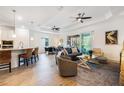 Open-concept living space with wood-look tile flooring, a spacious living area, and a view of the screened lanai at 14684 Cherry Blossom Way, Punta Gorda, FL 33955